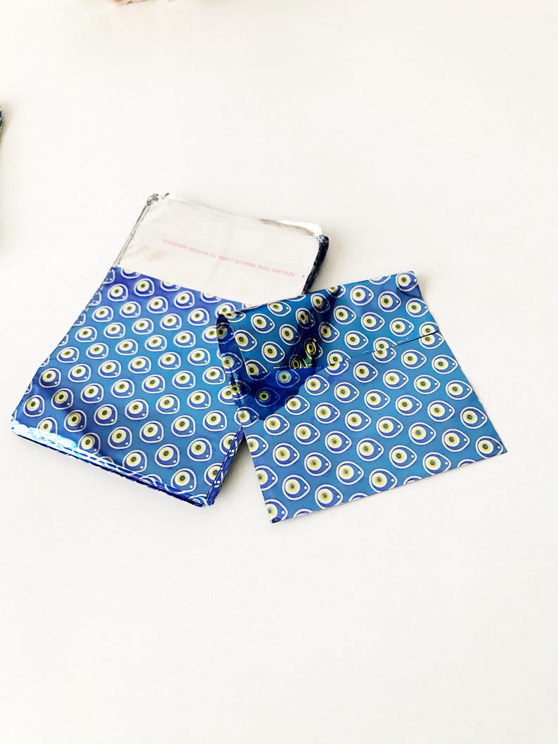 A collection of 100 elegant evil eye gift bags in white, blue, and gray, featuring the traditional Turkish evil eye design.