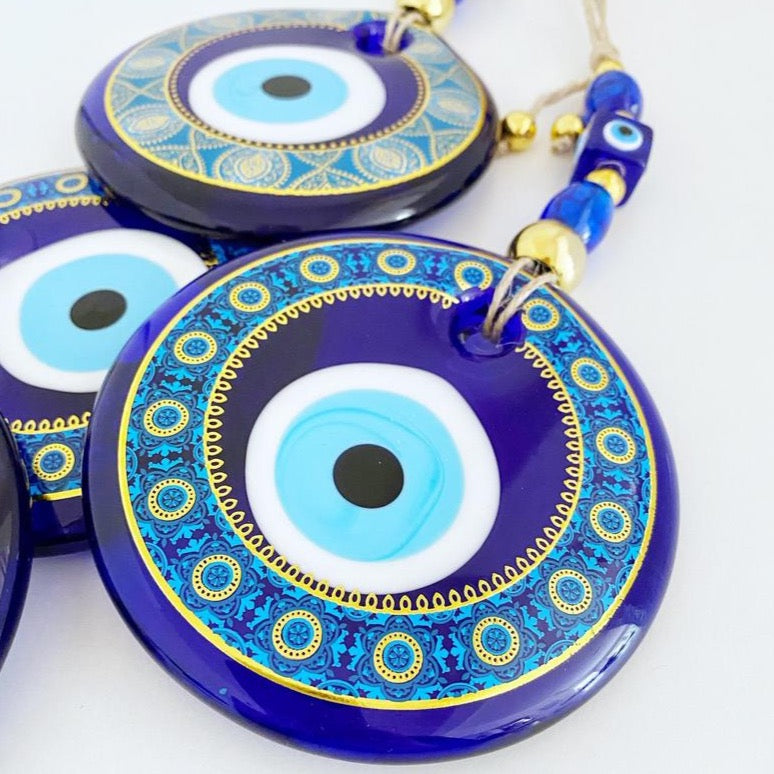 A beautifully hand-painted 11cm Evil Eye wall hanging featuring intricate blue patterns, symbolizing protection and good fortune.