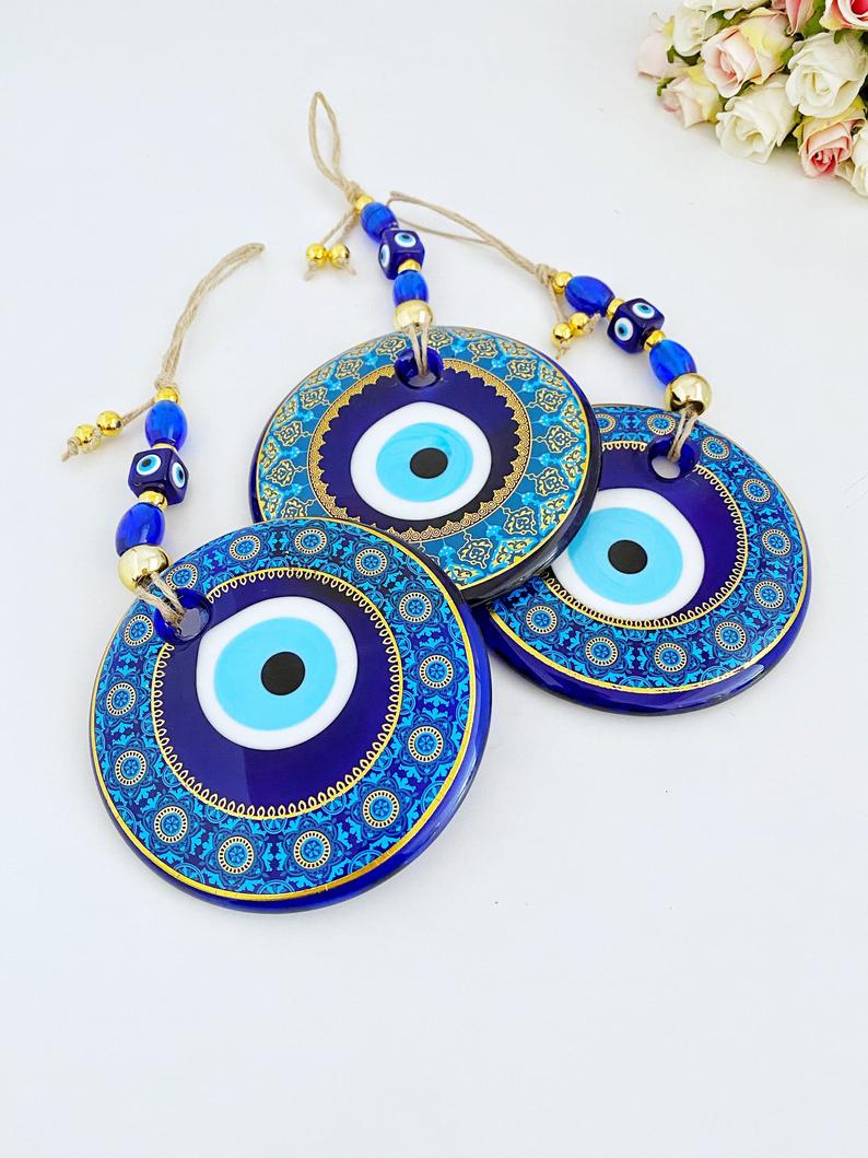 A beautifully hand-painted 11cm Evil Eye wall hanging featuring intricate blue patterns, symbolizing protection and good fortune.