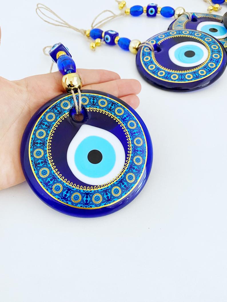 A beautifully hand-painted 11cm Evil Eye wall hanging featuring intricate blue patterns, symbolizing protection and good fortune.