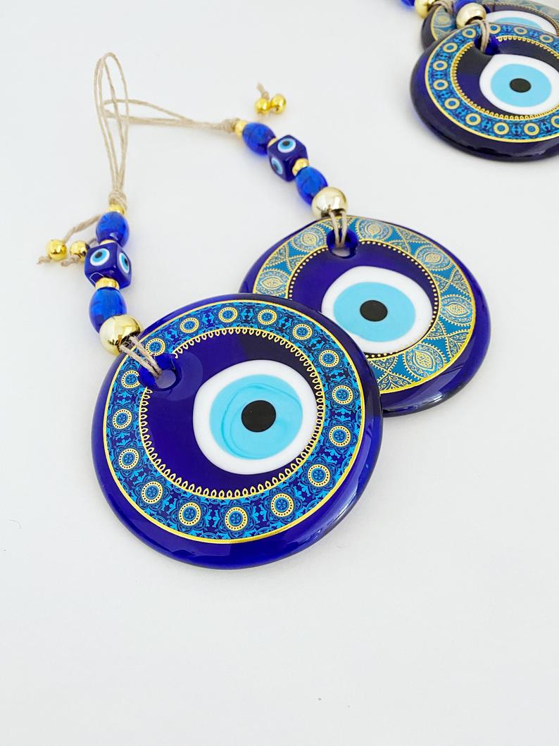 A beautifully hand-painted 11cm Evil Eye wall hanging featuring intricate blue patterns, symbolizing protection and good fortune.