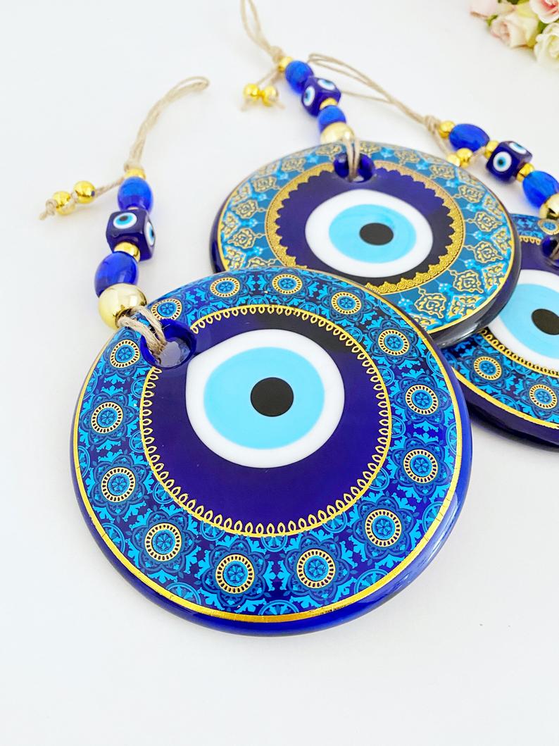 A beautifully hand-painted 11cm Evil Eye wall hanging featuring intricate blue patterns, symbolizing protection and good fortune.