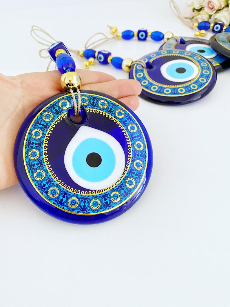 A beautifully hand-painted 11cm Evil Eye wall hanging featuring intricate blue patterns, symbolizing protection and good fortune.