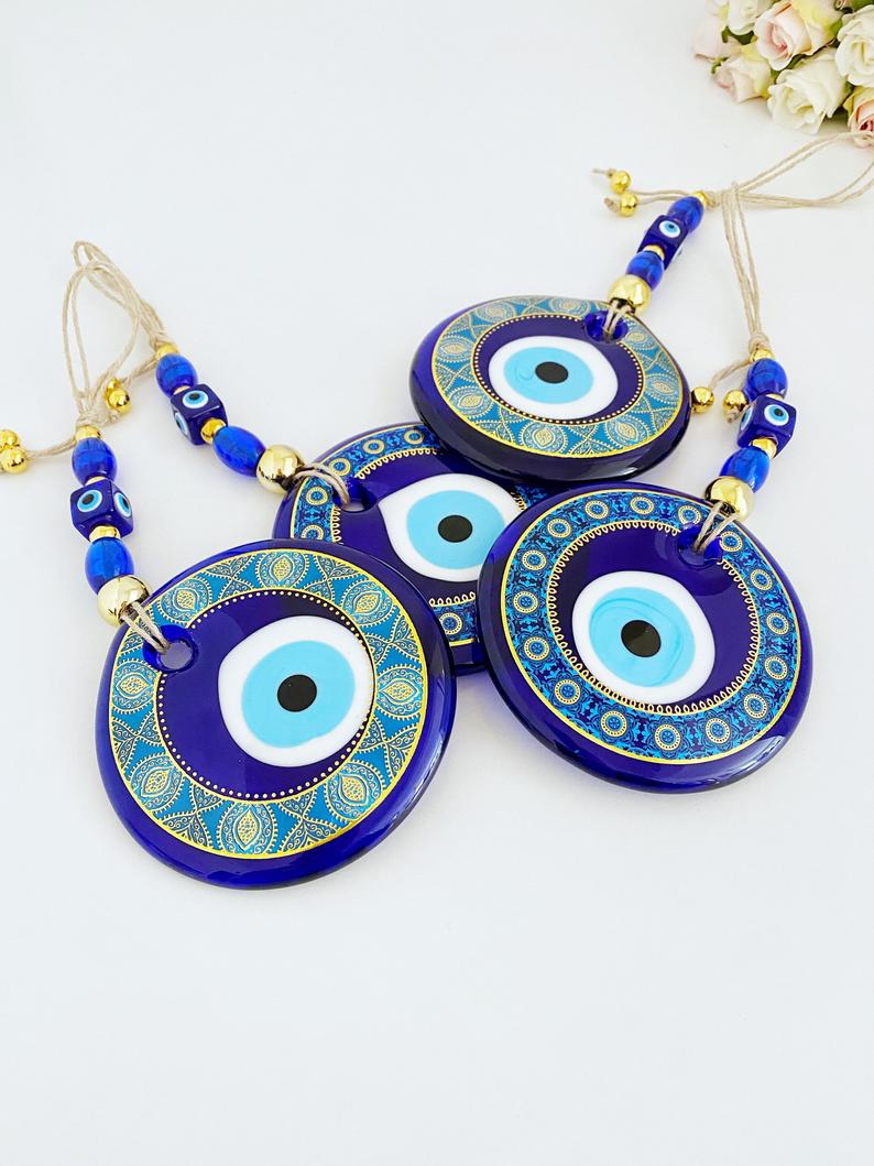 A beautifully hand-painted 11cm Evil Eye wall hanging featuring intricate blue patterns, symbolizing protection and good fortune.