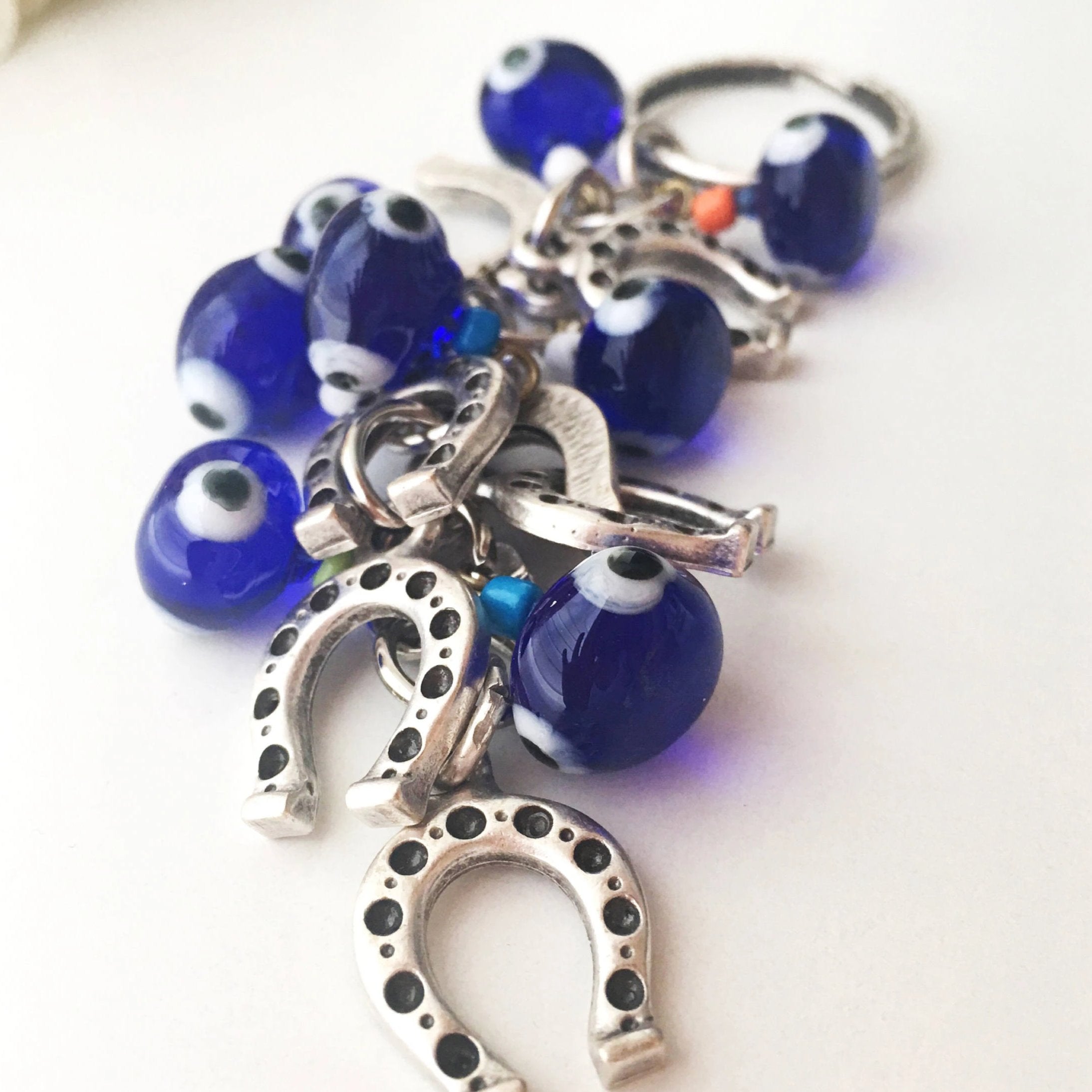 Evil eye horseshoe charm keychain featuring a blue glass evil eye and silver plated horseshoe, symbolizing good luck and protection.