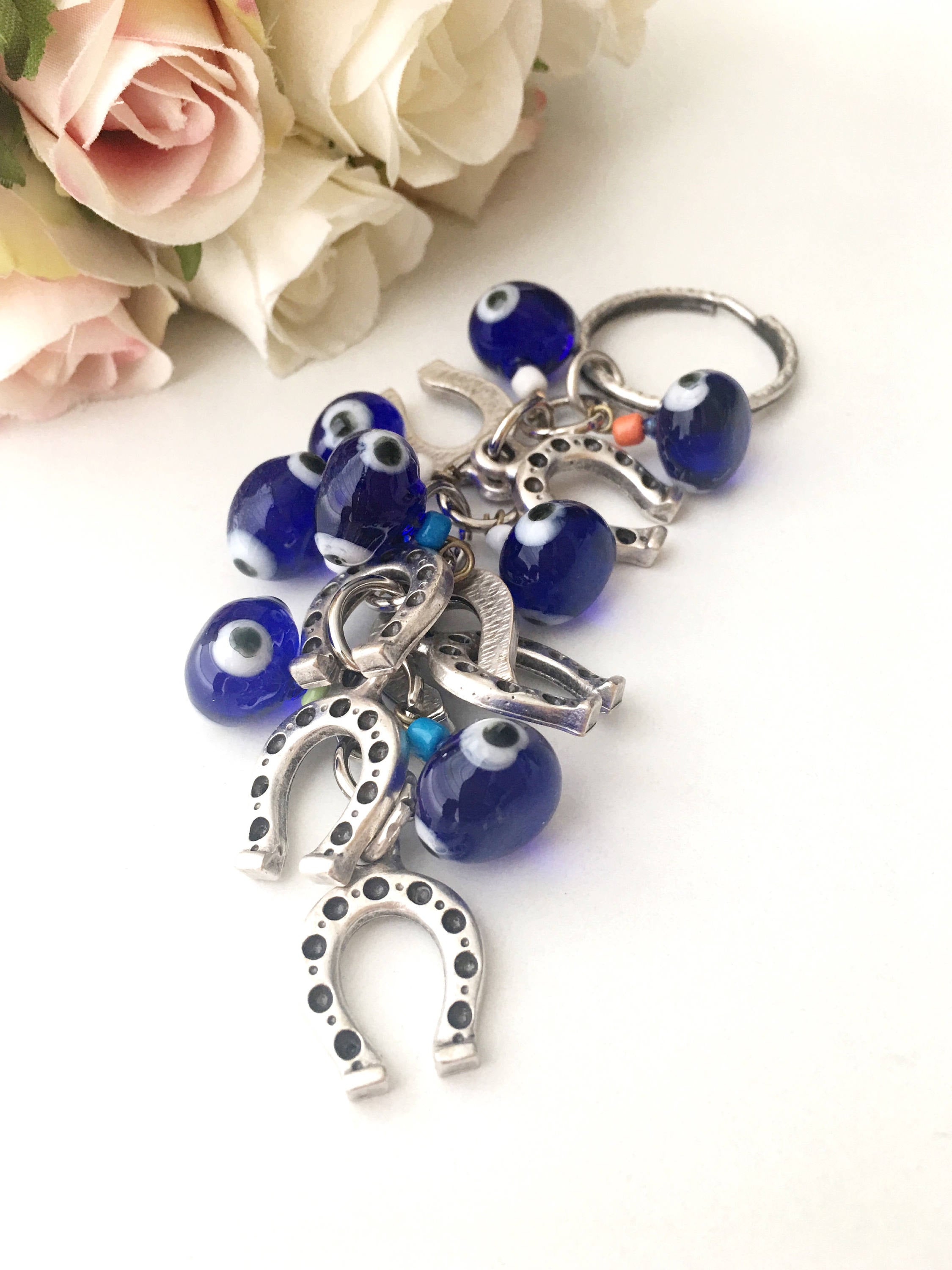 Evil eye horseshoe charm keychain featuring a blue glass evil eye and silver plated horseshoe, symbolizing good luck and protection.