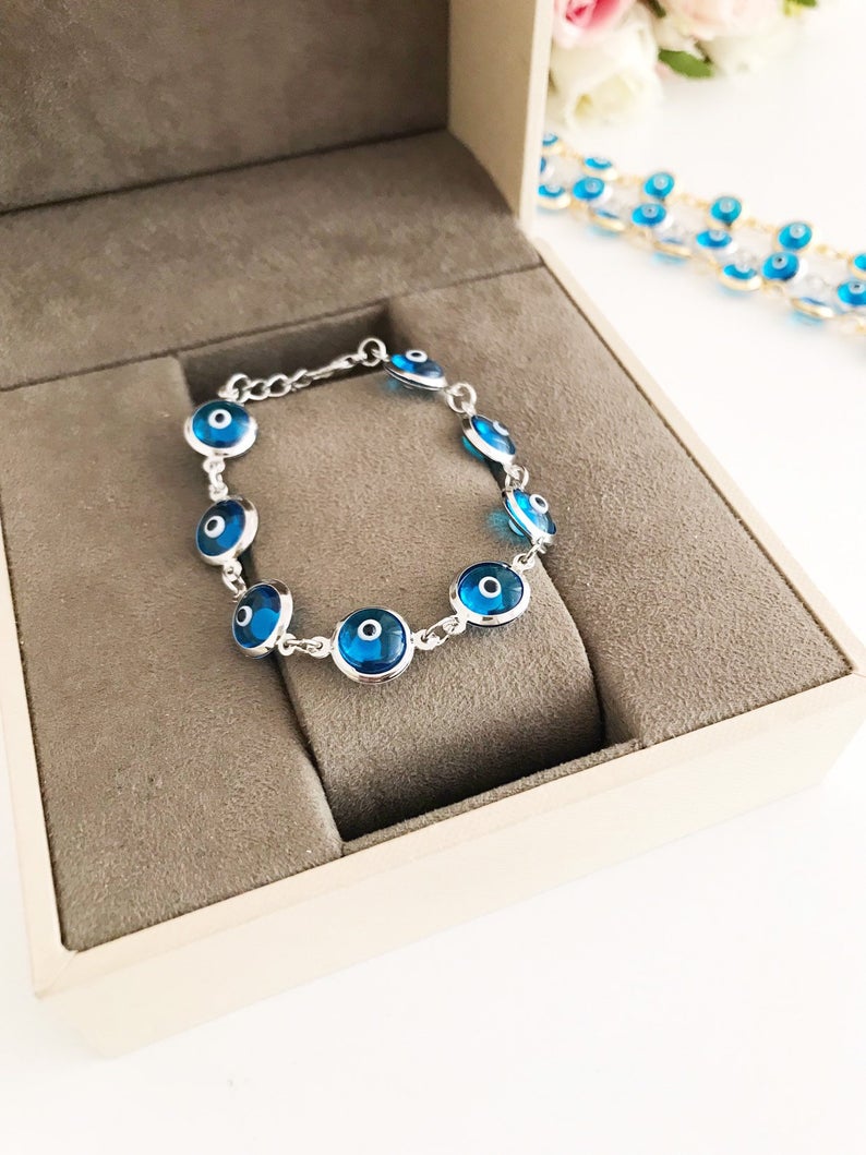 Evil Eye Jewelry featuring a gold and silver link chain bracelet with turquoise evil eye beads, symbolizing protection and style.