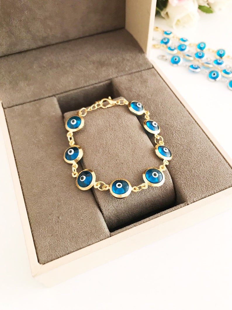 Evil Eye Jewelry featuring a gold and silver link chain bracelet with turquoise evil eye beads, symbolizing protection and style.