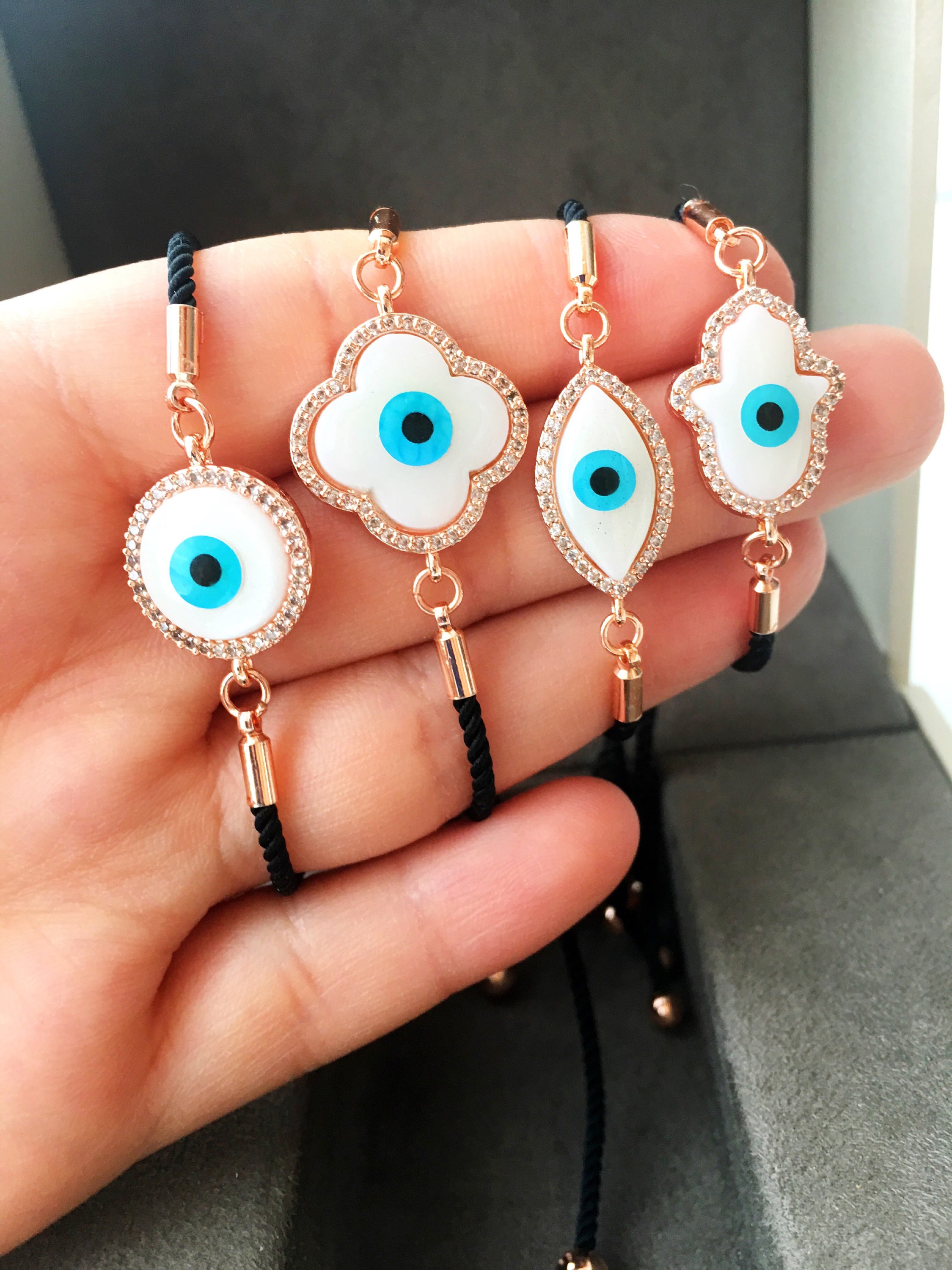 A beautifully crafted Mother of Pearl Adjustable Bracelet featuring an evil eye charm surrounded by zirconia, showcasing its unique design and handmade quality.