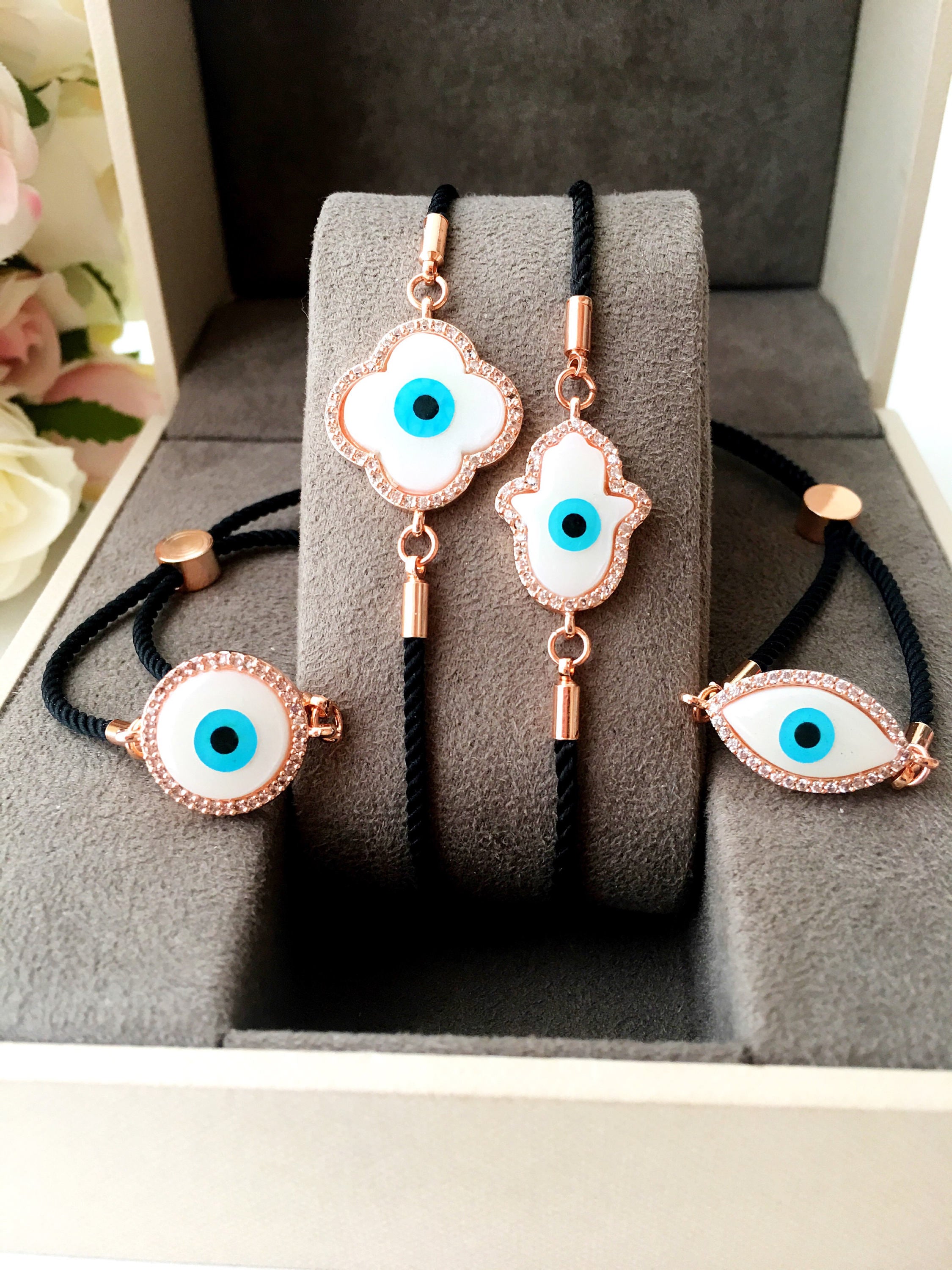 A beautifully crafted Mother of Pearl Adjustable Bracelet featuring an evil eye charm surrounded by zirconia, showcasing its unique design and handmade quality.