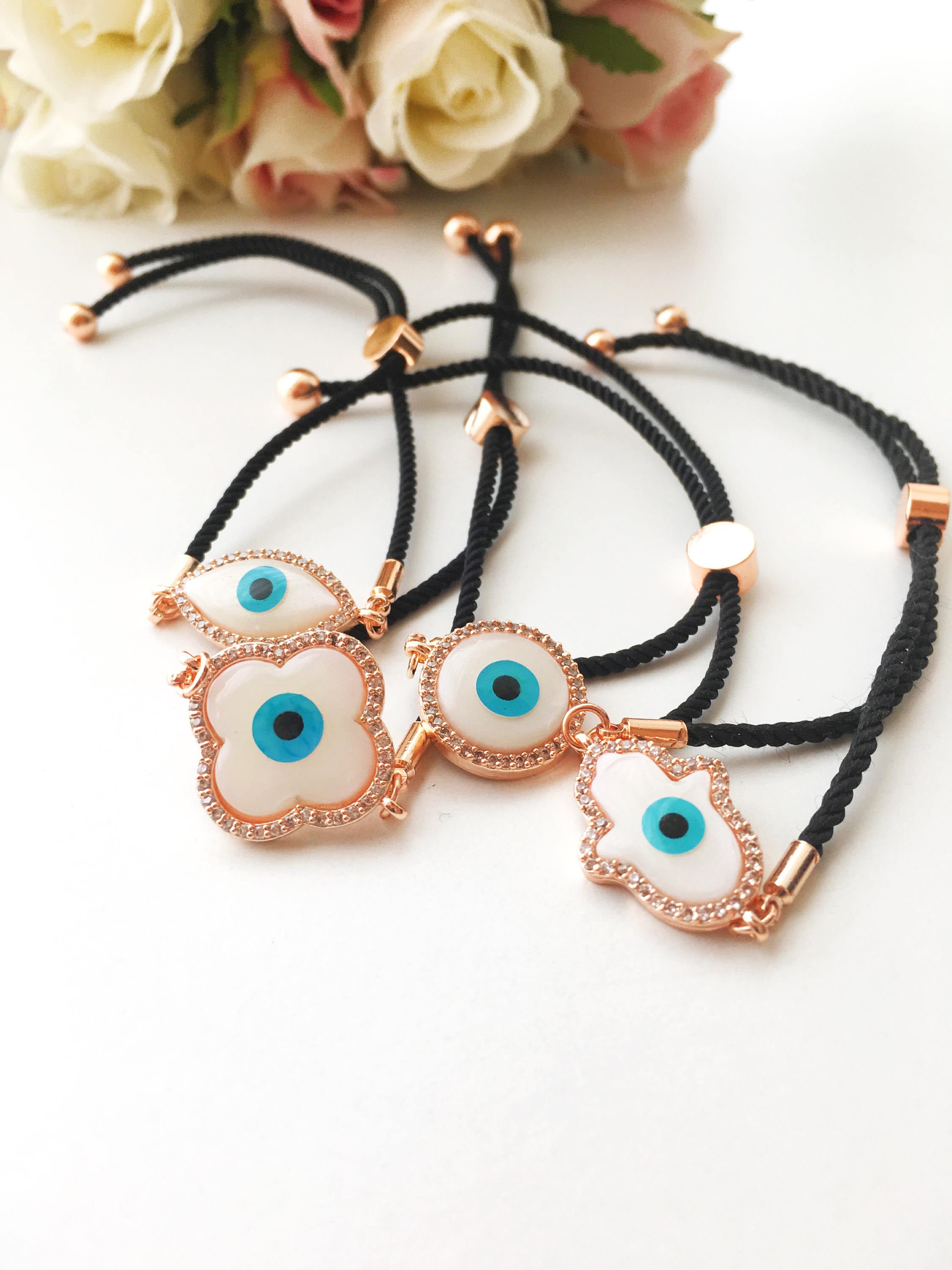 A beautifully crafted Mother of Pearl Adjustable Bracelet featuring an evil eye charm surrounded by zirconia, showcasing its unique design and handmade quality.