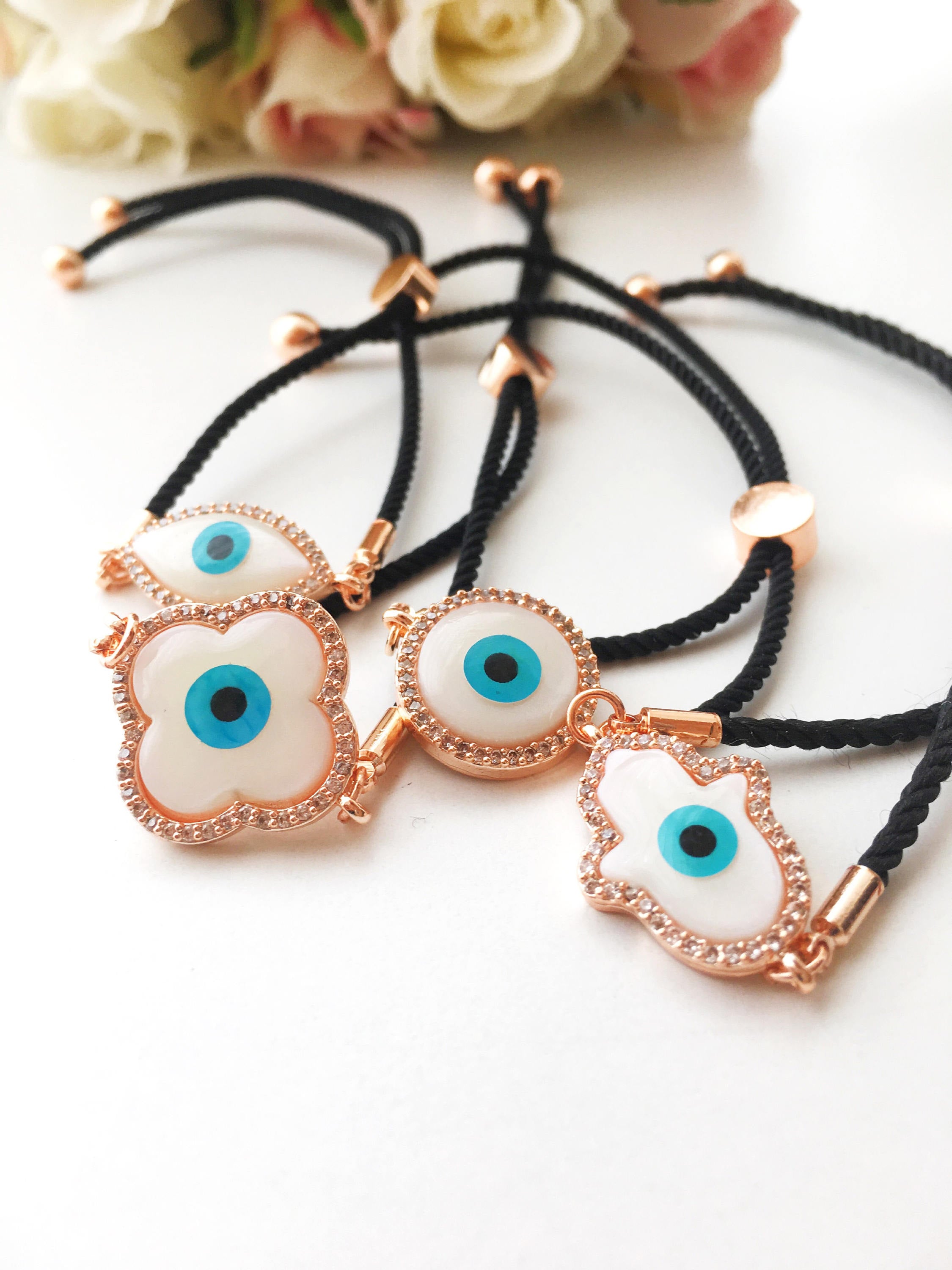 A beautifully crafted Mother of Pearl Adjustable Bracelet featuring an evil eye charm surrounded by zirconia, showcasing its unique design and handmade quality.