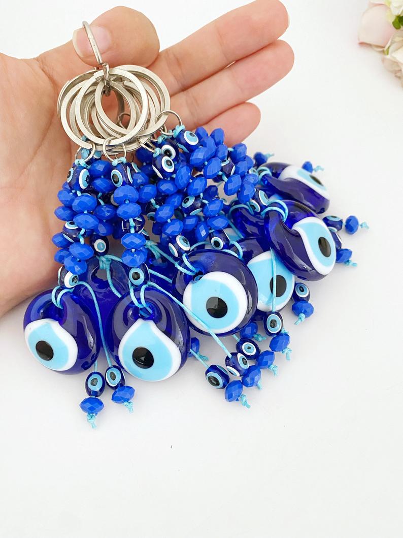 A beautiful Evil Eye Keychain featuring a glass evil eye bead surrounded by tiny blue beads, symbolizing protection and good luck.