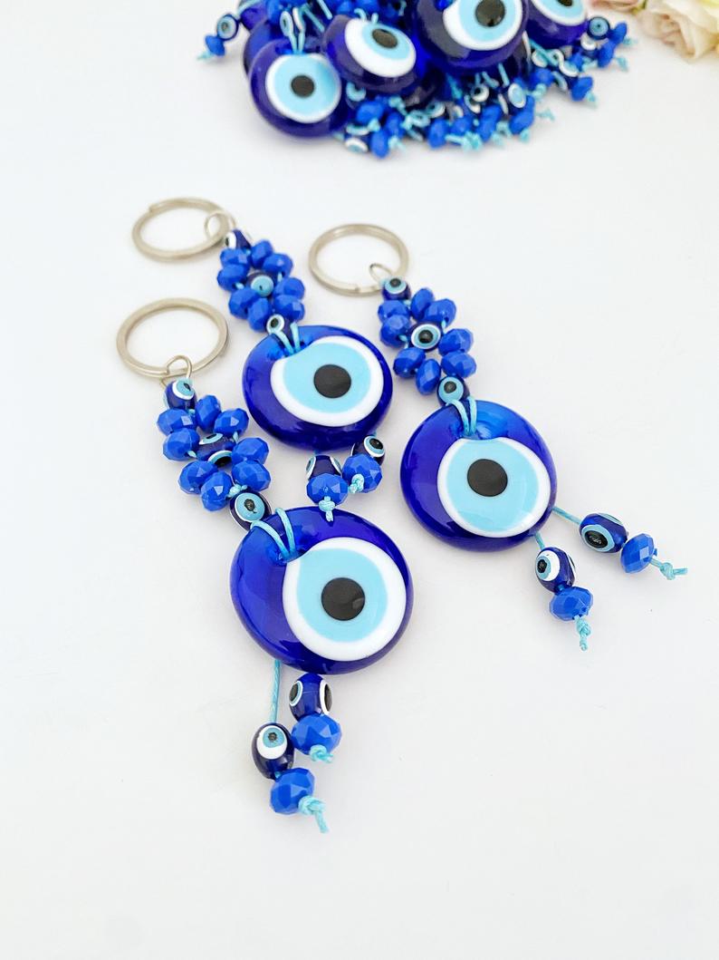 A beautiful Evil Eye Keychain featuring a glass evil eye bead surrounded by tiny blue beads, symbolizing protection and good luck.