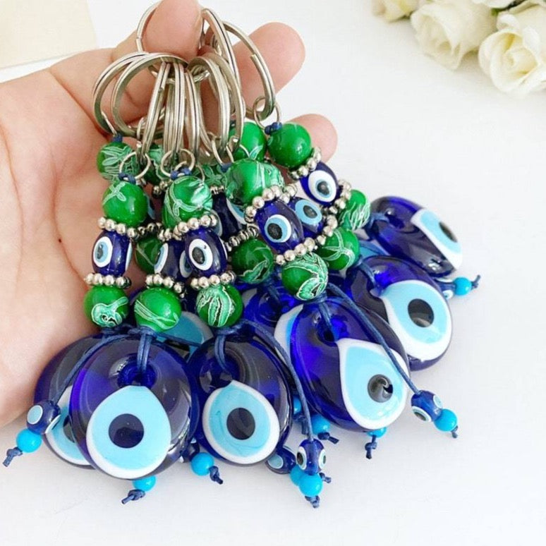 Evil Eye Keychain featuring green beads and a blue glass evil eye bead, symbolizing protection and good luck.