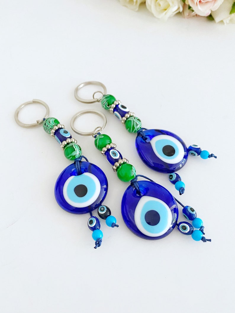 Evil Eye Keychain featuring green beads and a blue glass evil eye bead, symbolizing protection and good luck.