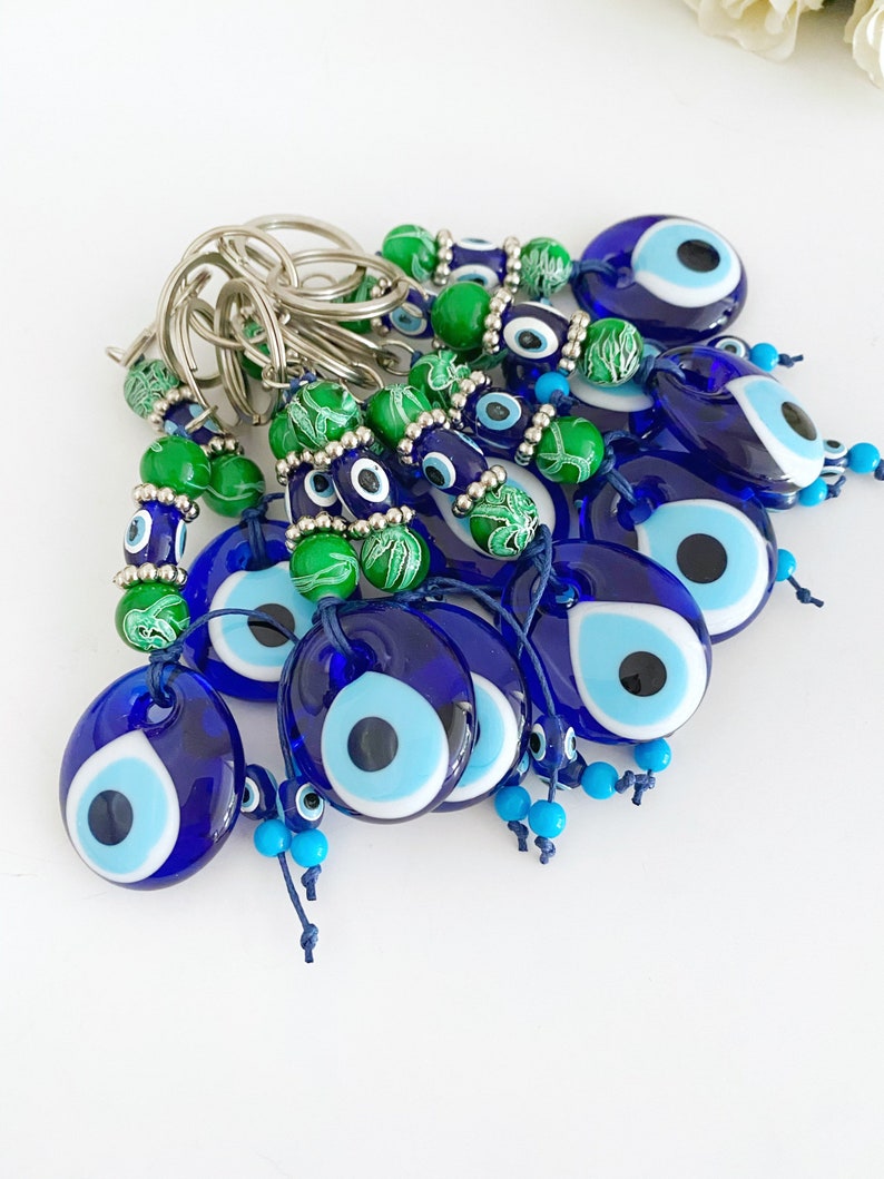 Evil Eye Keychain featuring green beads and a blue glass evil eye bead, symbolizing protection and good luck.