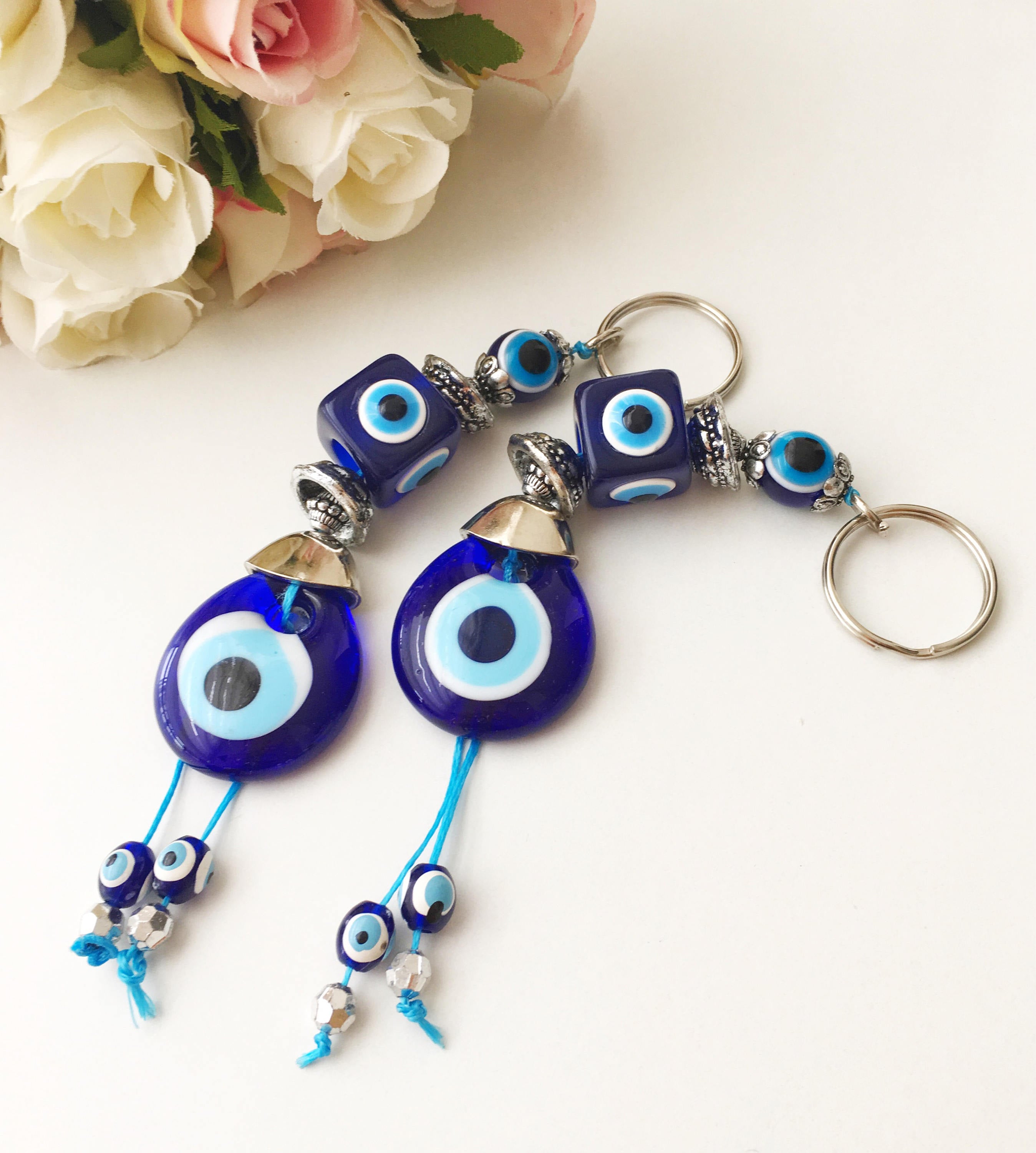 A beautifully crafted Evil Eye keychain featuring vibrant blue and white beads, symbolizing protection and good luck, attached to a silver keyring.