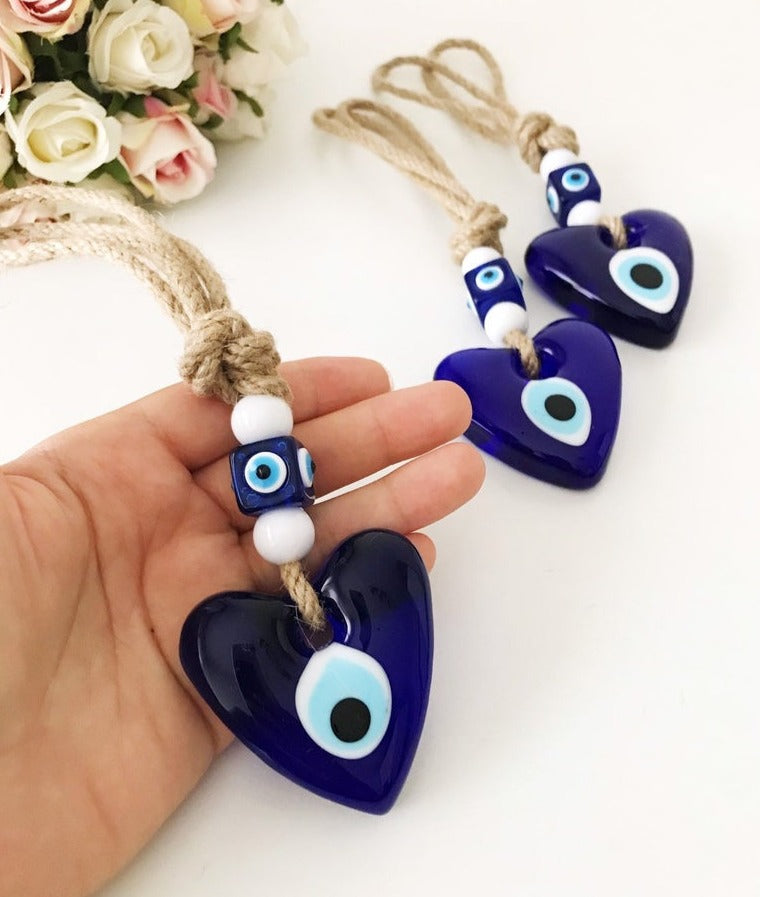 Evil Eye Love wall hanging featuring a heart design with blue evil eye beads and macrame elements, perfect for home decor.