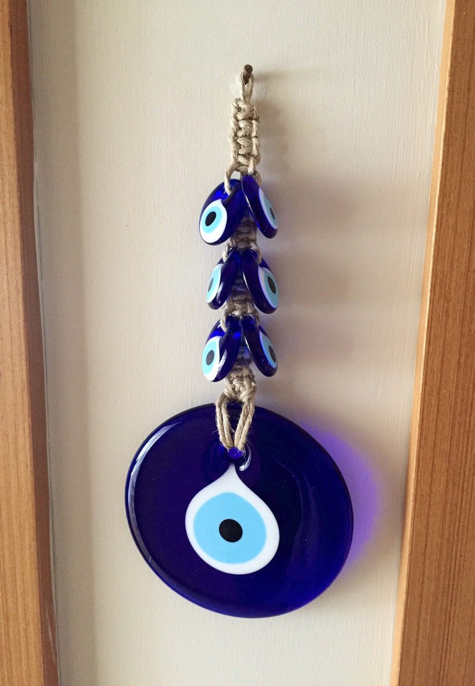 Handmade Evil Eye Macrame Wall Hanging featuring a large 7cm evil eye and six smaller glass evil eyes, intricately designed for wall decor.