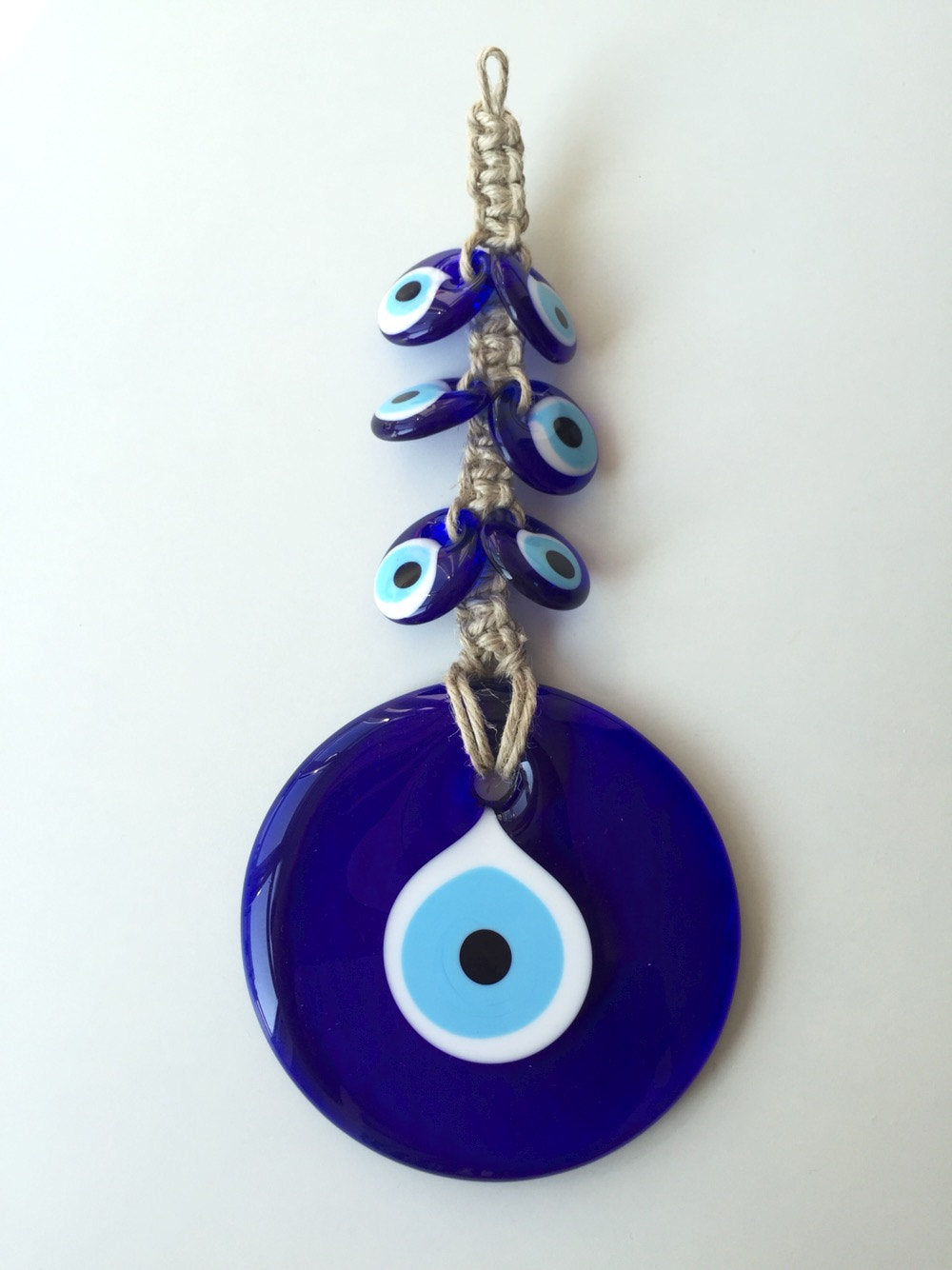 Handmade Evil Eye Macrame Wall Hanging featuring a large 7cm evil eye and six smaller glass evil eyes, intricately designed for wall decor.