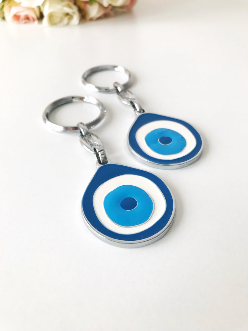 A beautifully designed Evil Eye metal keychain featuring an intricate enamel design, symbolizing luck and protection.