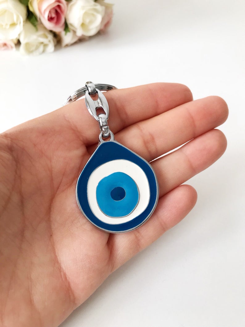 A beautifully designed Evil Eye metal keychain featuring an intricate enamel design, symbolizing luck and protection.