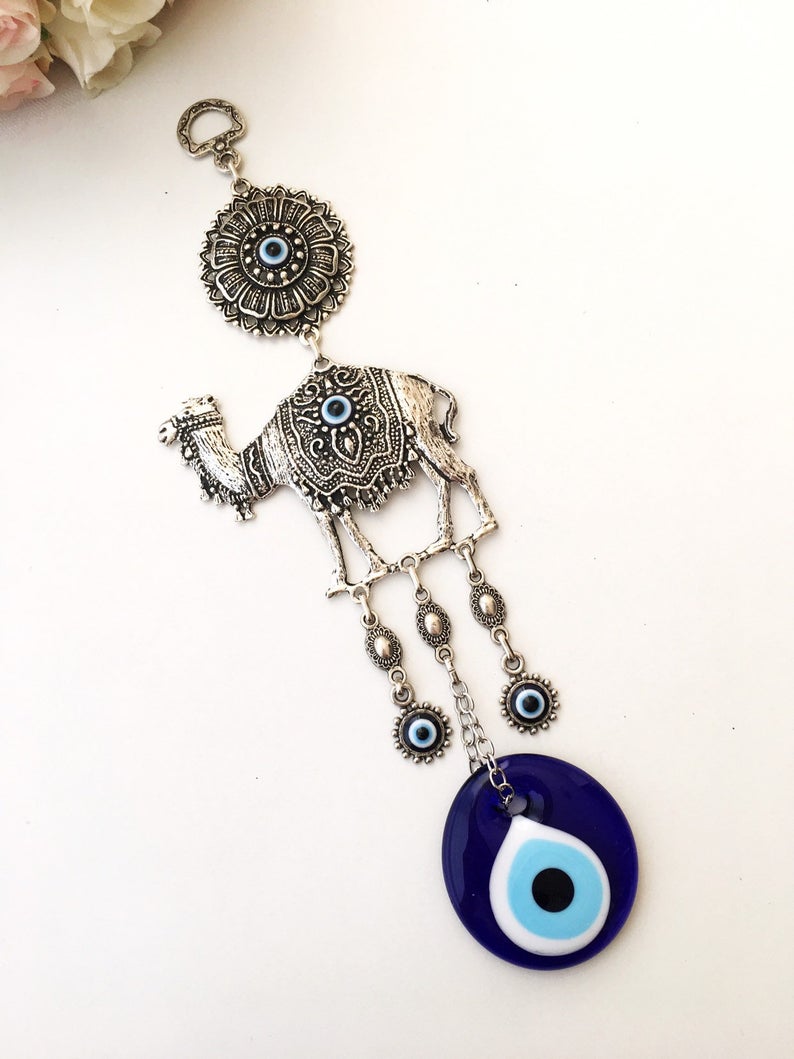 Evil eye metal wall hangings featuring various animal designs, crafted with blue glass evil eye beads and metal charms.