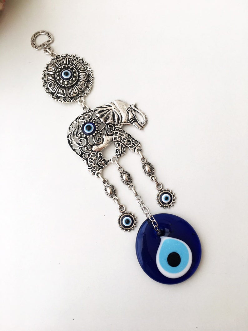 Evil eye metal wall hangings featuring various animal designs, crafted with blue glass evil eye beads and metal charms.