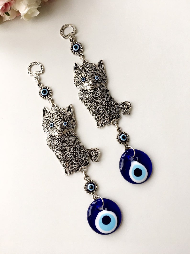 Evil eye metal wall hangings featuring various animal designs, crafted with blue glass evil eye beads and metal charms.