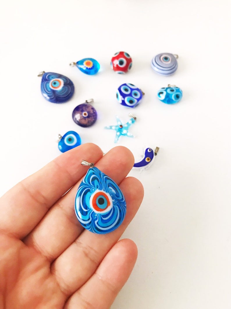 Handmade Murano glass evil eye pendant featuring vibrant blue and intricate designs, symbolizing protection and good luck.