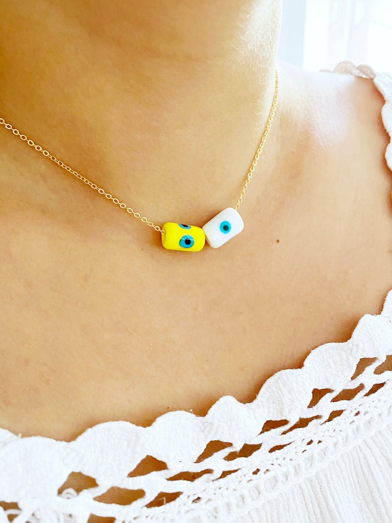 A beautifully handcrafted Evil Eye Necklace featuring colorful Murano tube beads and a stainless steel chain in gold or silver.