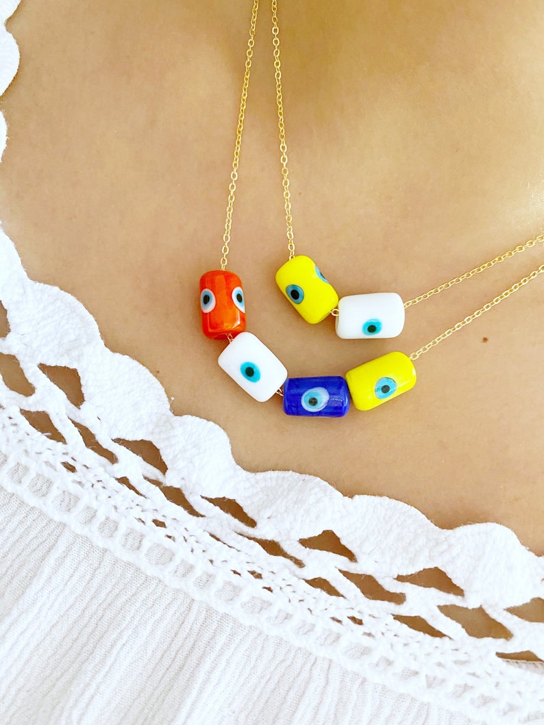 A beautifully handcrafted Evil Eye Necklace featuring colorful Murano tube beads and a stainless steel chain in gold or silver.