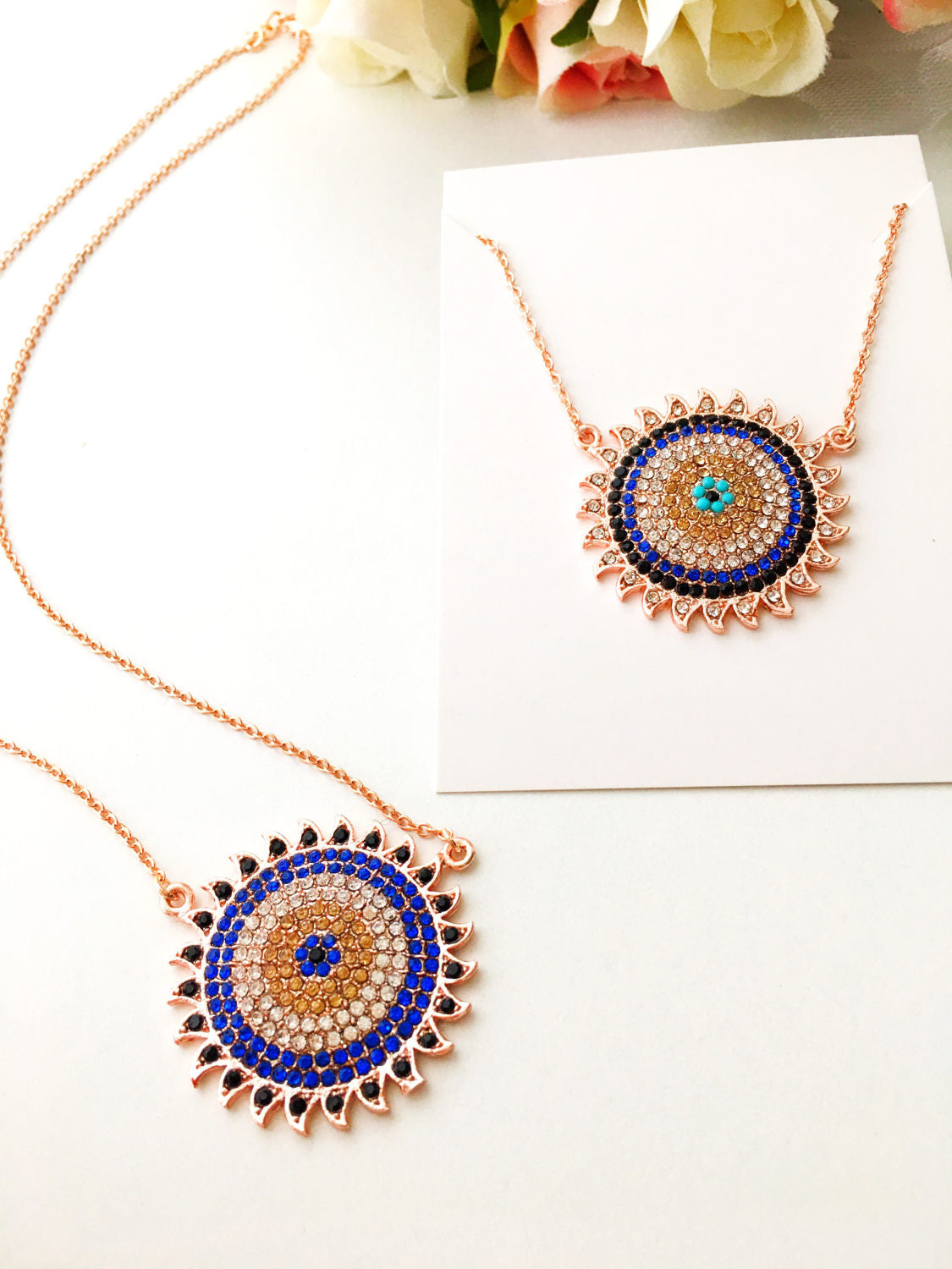 Handmade gold evil eye necklace with zirconia sun pendant, featuring an adjustable chain and unique design.