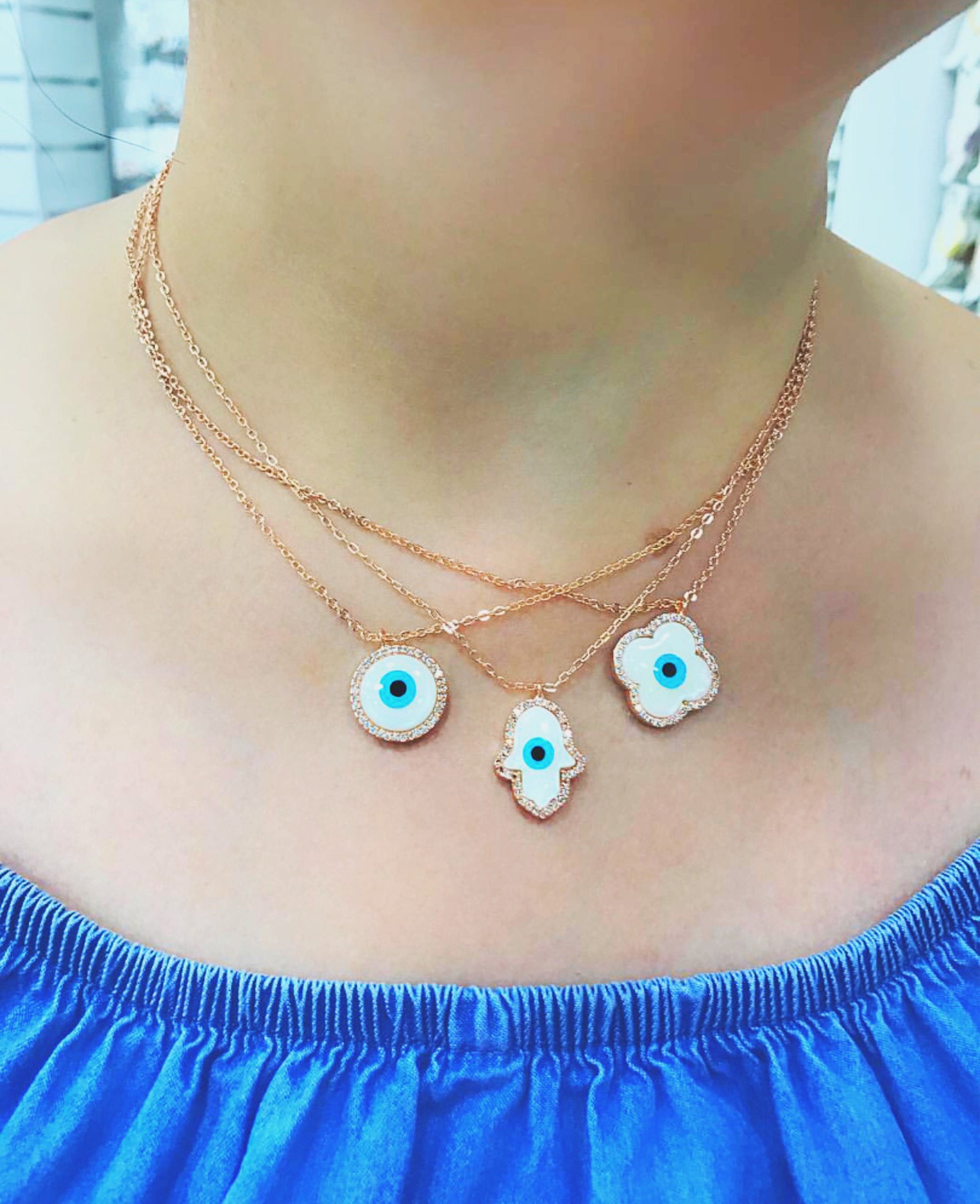 Elegant evil eye necklace featuring a mother of pearl charm and rose gold clover design, showcasing its unique handmade craftsmanship.