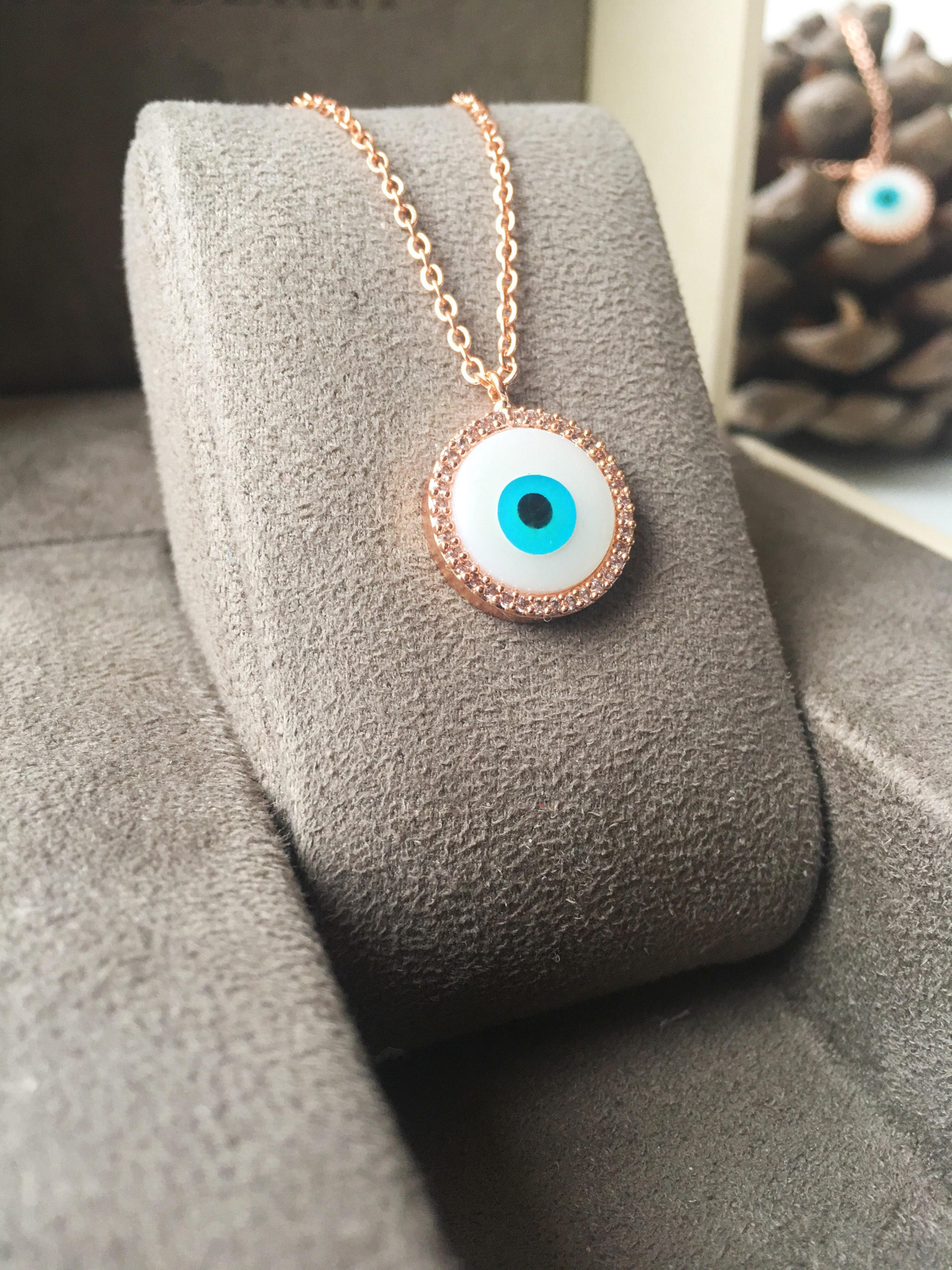 Elegant evil eye necklace featuring a mother of pearl charm and rose gold clover design, showcasing its unique handmade craftsmanship.