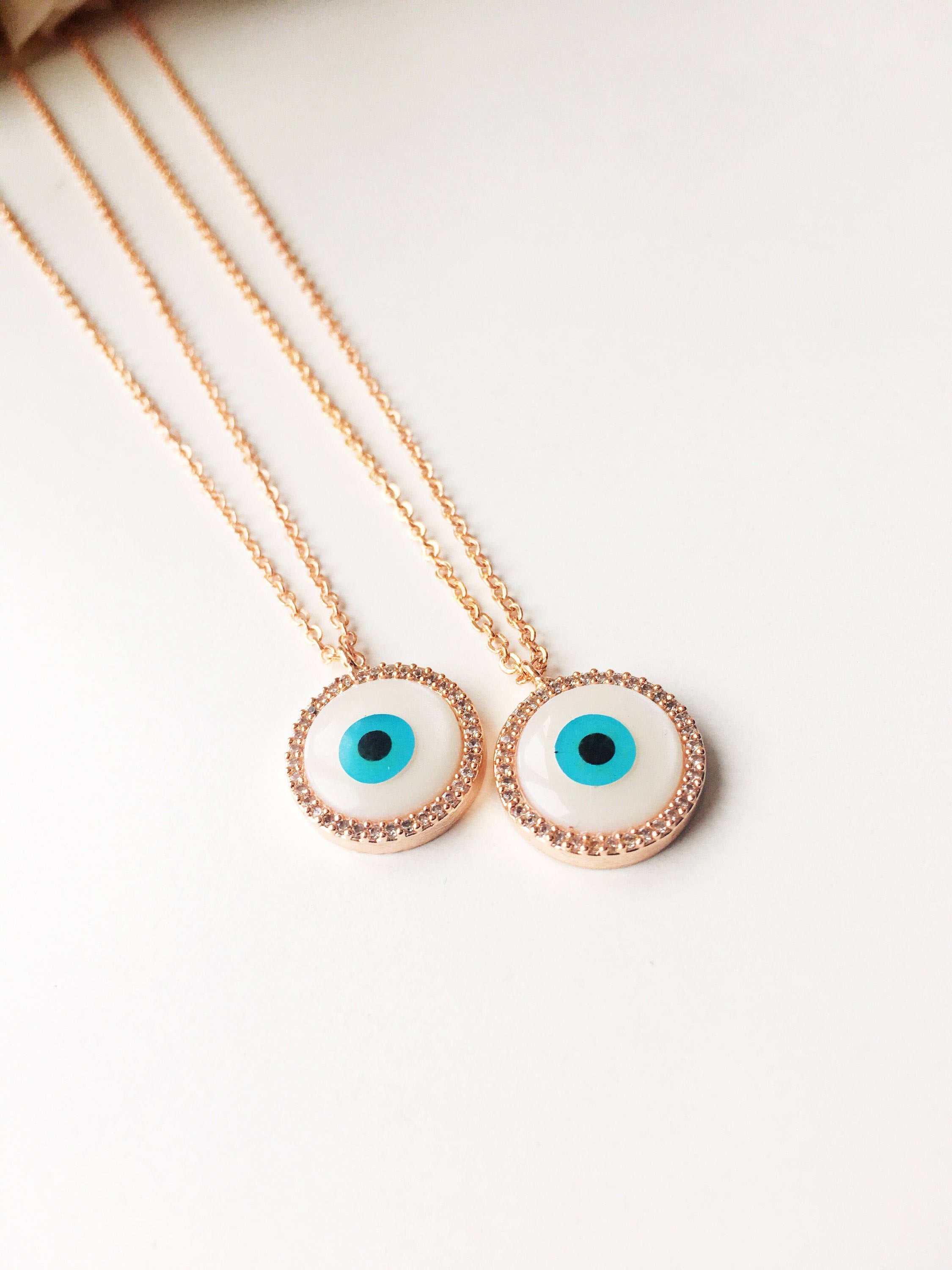 Elegant evil eye necklace featuring a mother of pearl charm and rose gold clover design, showcasing its unique handmade craftsmanship.