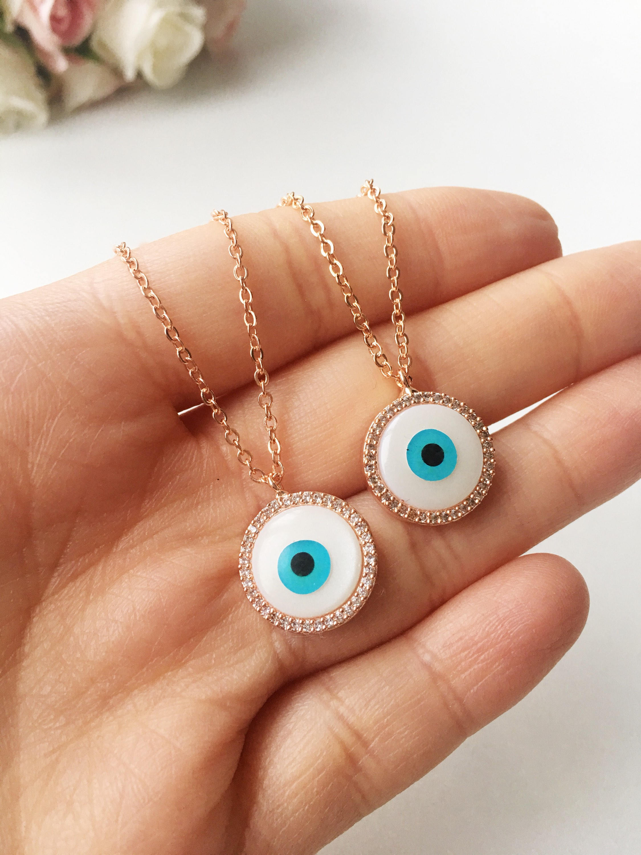 Elegant evil eye necklace featuring a mother of pearl charm and rose gold clover design, showcasing its unique handmade craftsmanship.