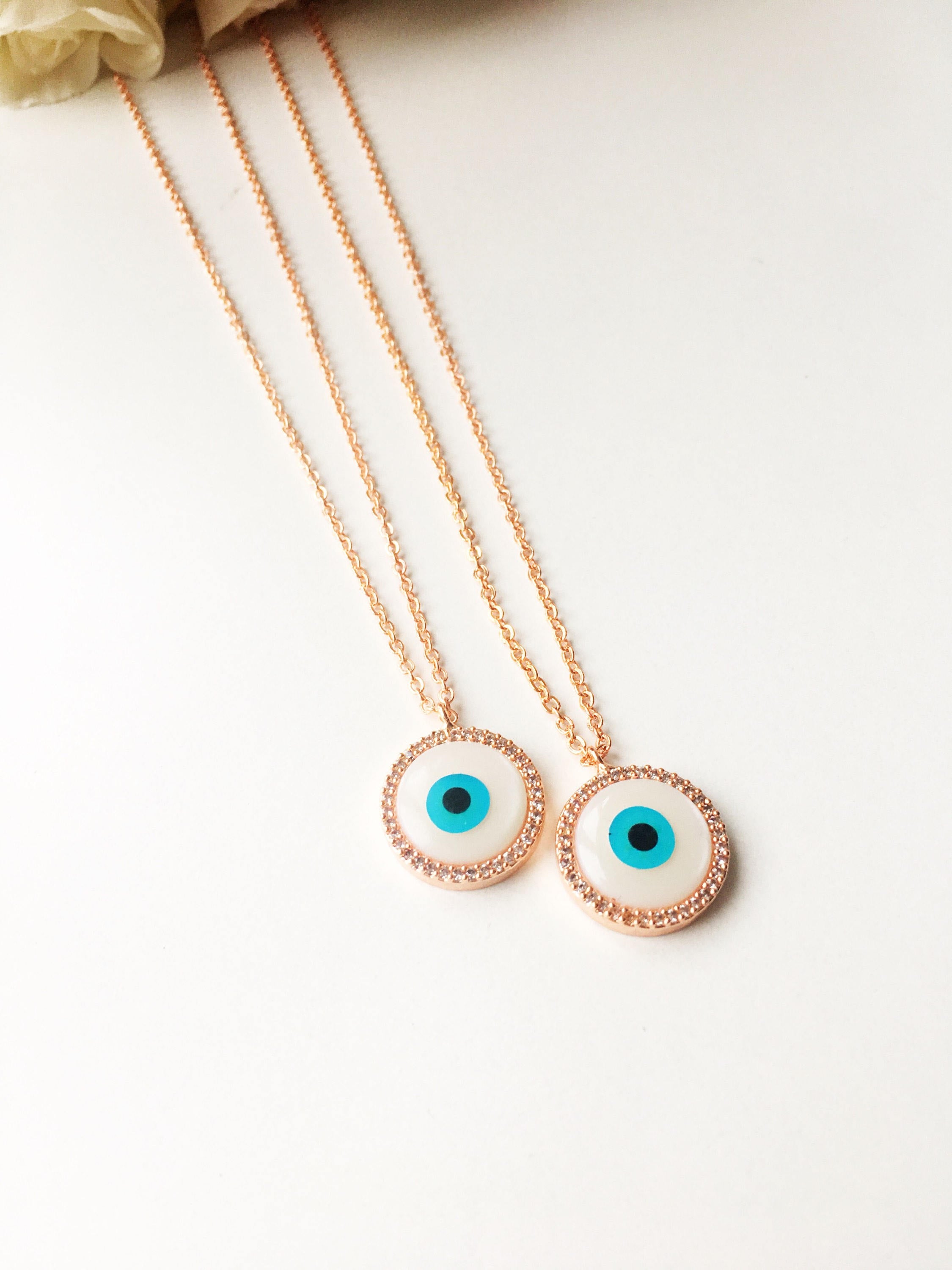 Elegant evil eye necklace featuring a mother of pearl charm and rose gold clover design, showcasing its unique handmade craftsmanship.