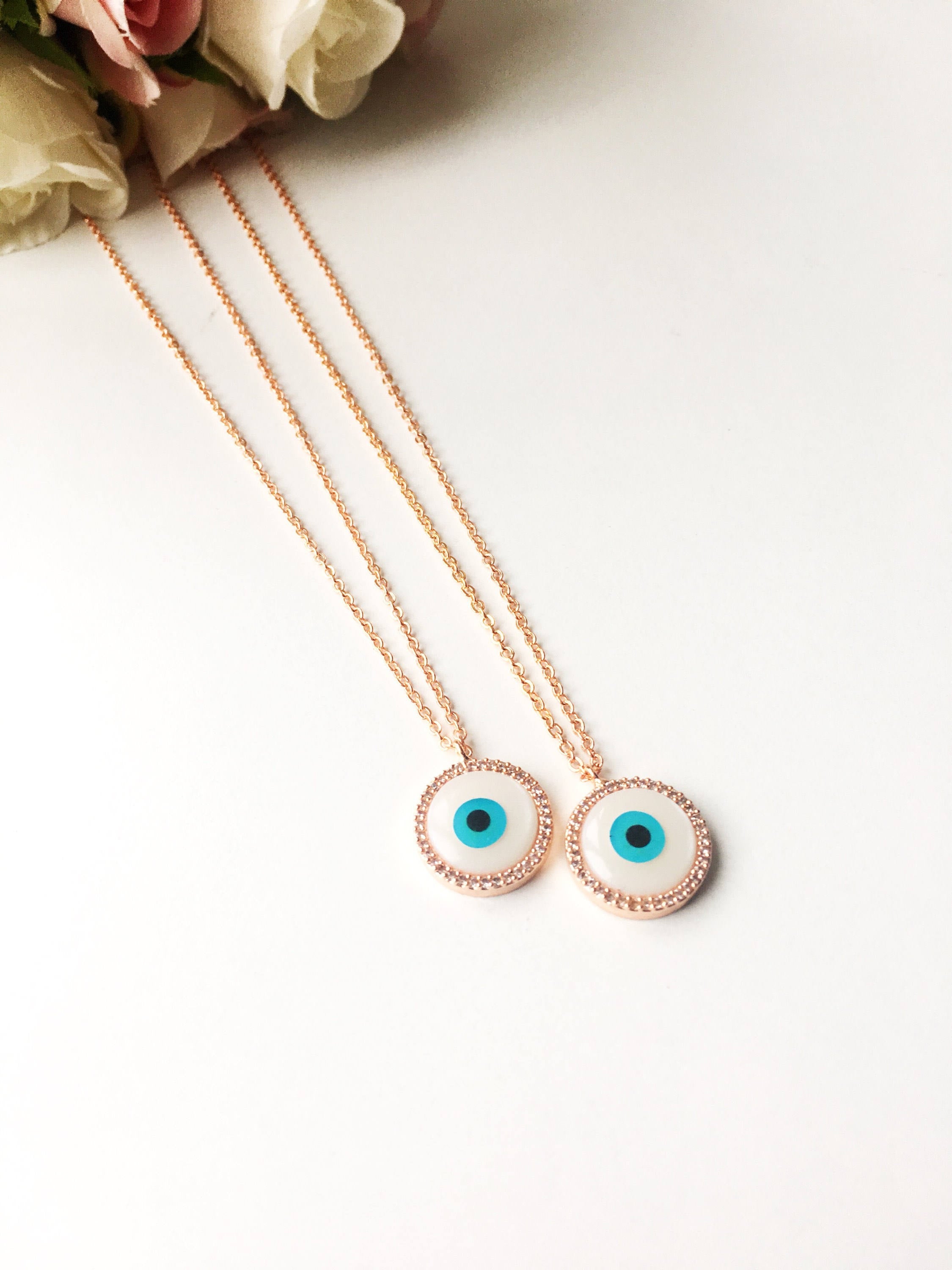 Elegant evil eye necklace featuring a mother of pearl charm and rose gold clover design, showcasing its unique handmade craftsmanship.