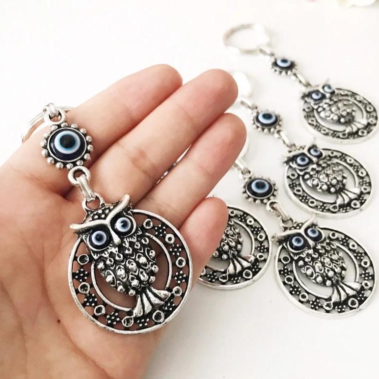 A beautiful Evil Eye Owl Keychain featuring a blue glass evil eye charm and a silver plated owl, perfect for keys or bags.