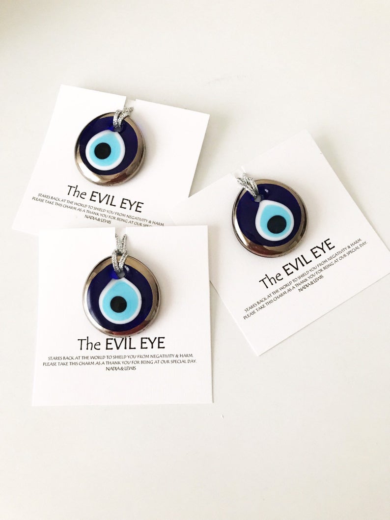 A collection of Evil Eye personalized wedding favors featuring blue glass beads with gold trim, beautifully arranged for display.