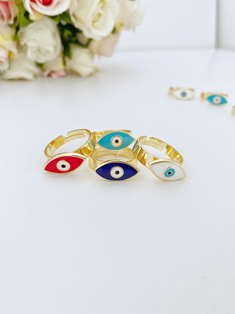 Adjustable Evil Eye Ring with gold band and colorful evil eye bead, available in blue, white, turquoise, and red.