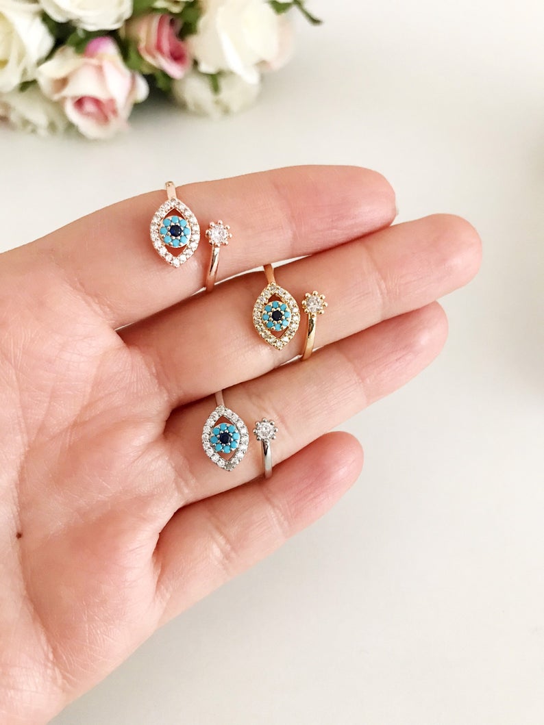 Evil Eye Ring featuring a blue eye design, available in gold, silver, and rose gold, adorned with zircon charms.