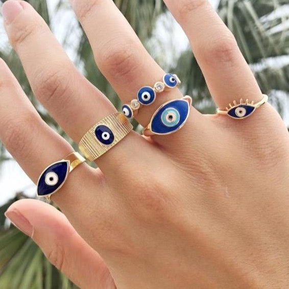 A beautiful set of gold adjustable evil eye rings featuring blue evil eye symbols, showcasing five unique styles for everyday wear.