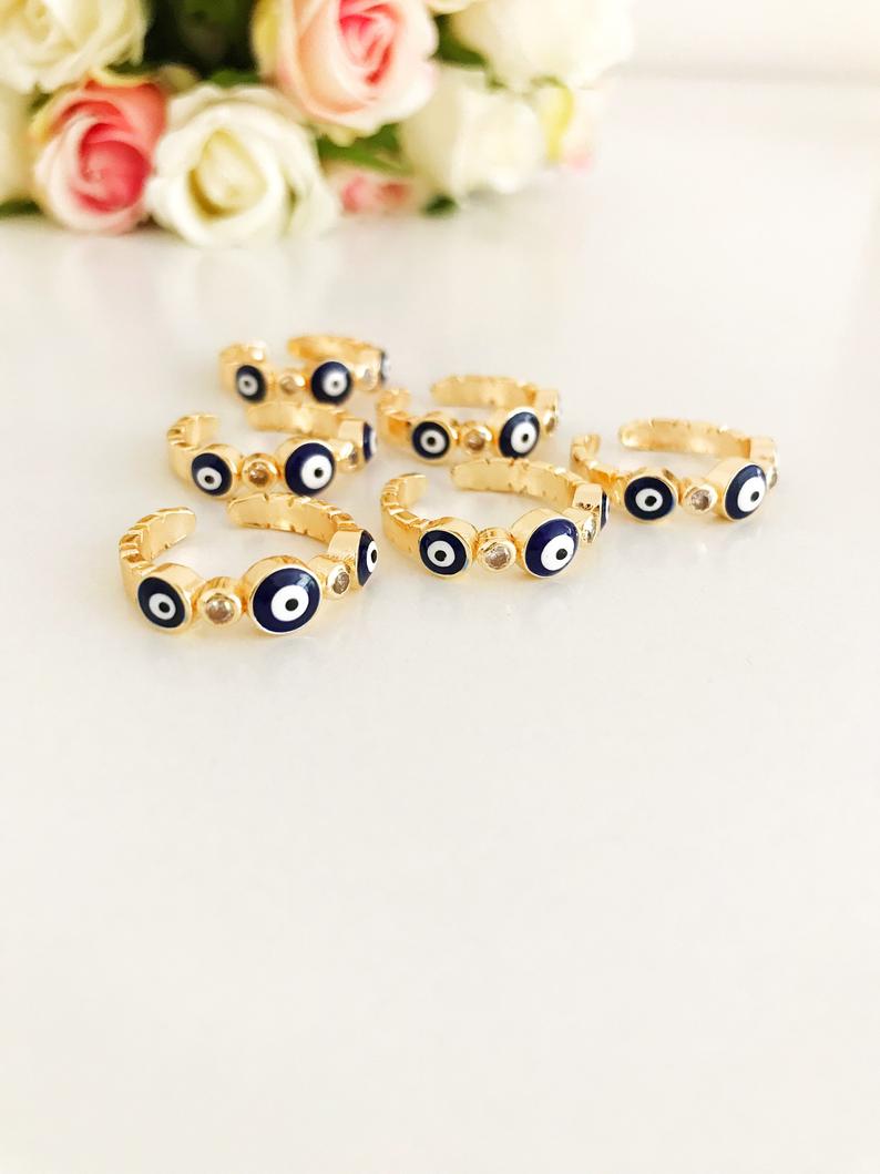 A beautiful set of gold adjustable evil eye rings featuring blue evil eye symbols, showcasing five unique styles for everyday wear.