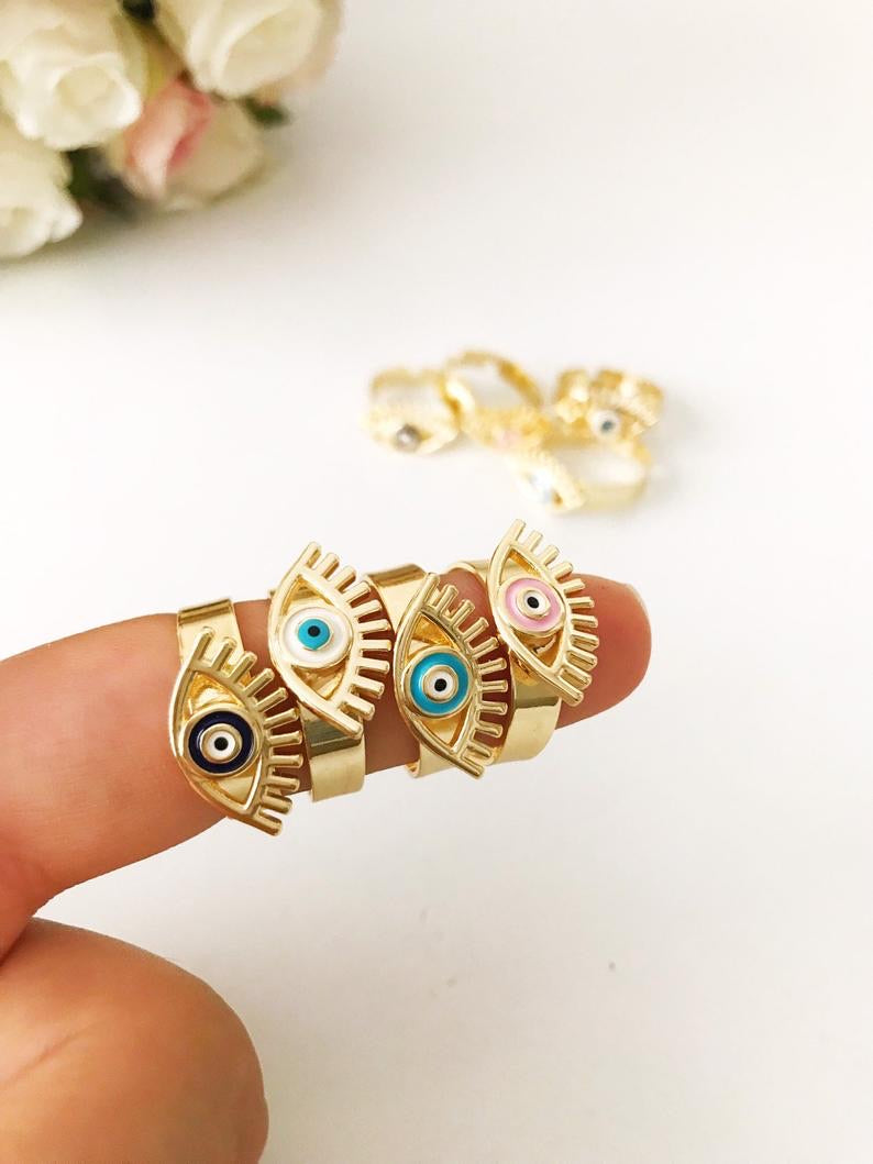 A beautiful adjustable Evil Eye Ring featuring a blue evil eye bead, designed in a dainty style with gold accents.