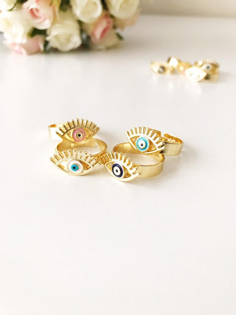 A beautiful adjustable Evil Eye Ring featuring a blue evil eye bead, designed in a dainty style with gold accents.