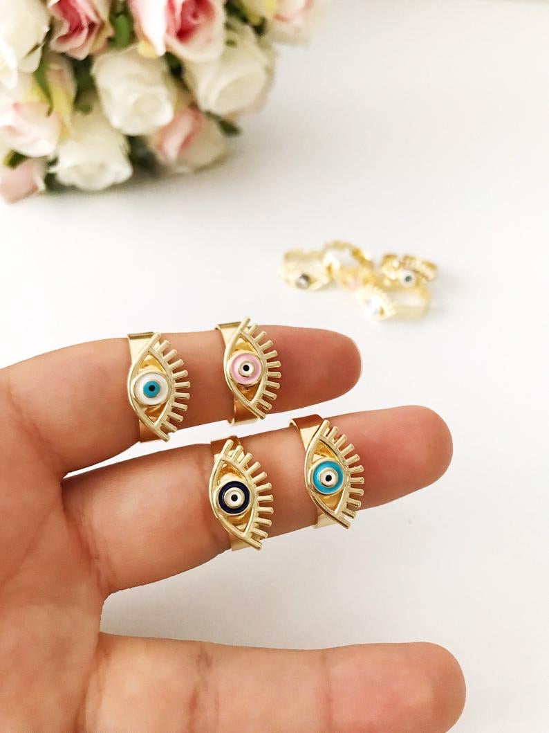 A beautiful adjustable Evil Eye Ring featuring a blue evil eye bead, designed in a dainty style with gold accents.