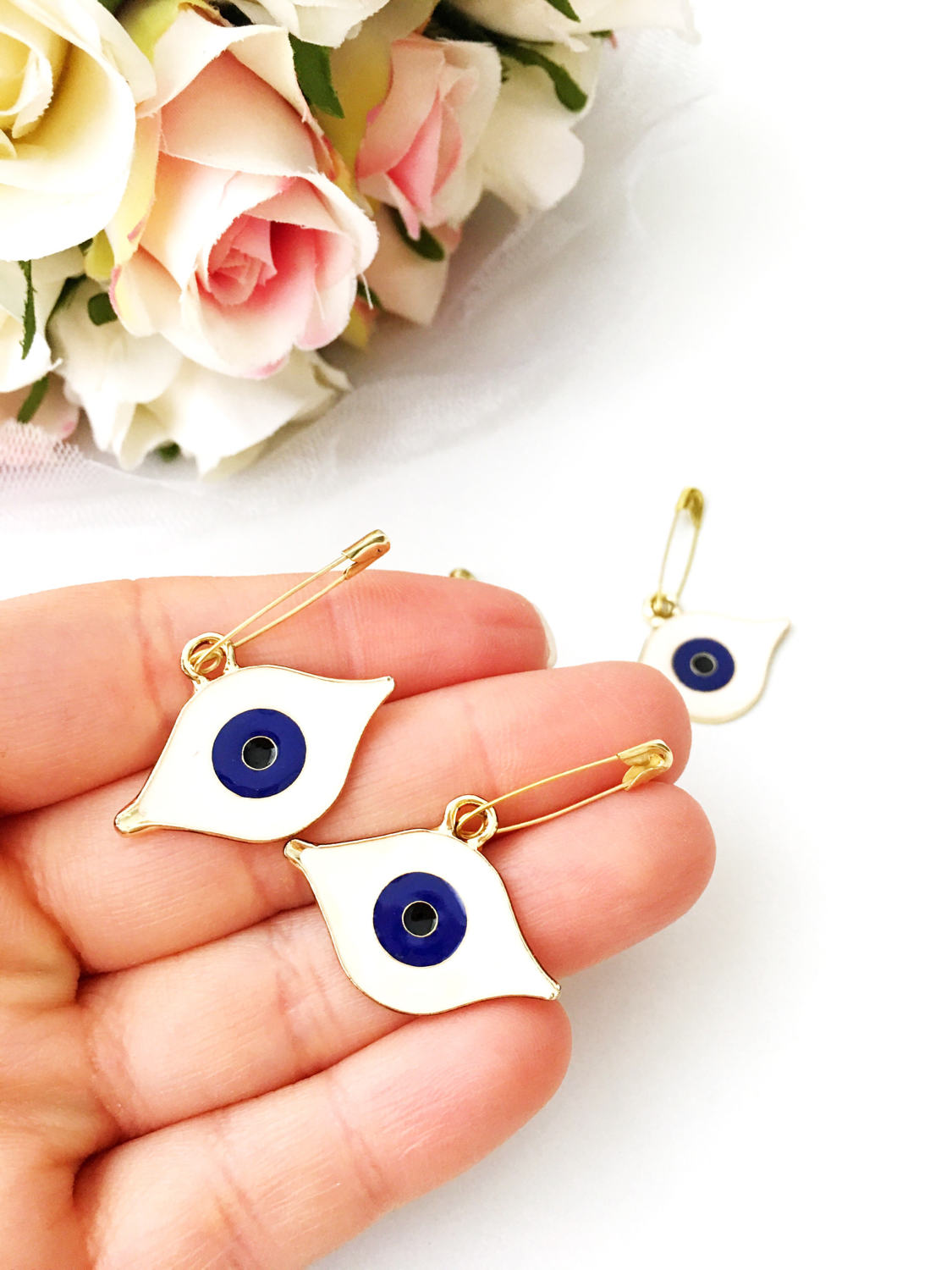 Gold plated evil eye safety pin with big enamel eye design, symbolizing protection and charm.